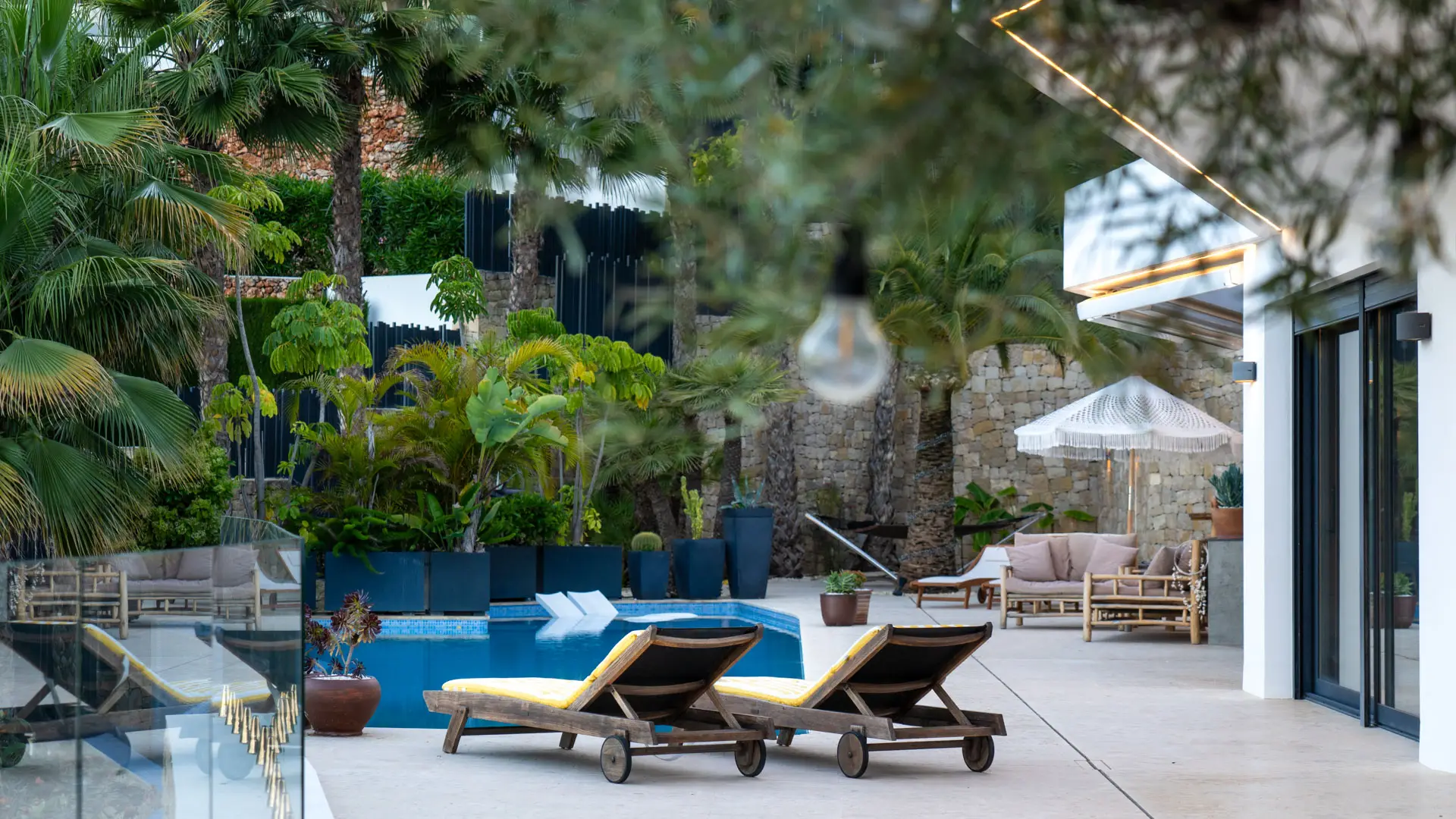 Jardín con palmeras y piscina de una vivienda de lujo