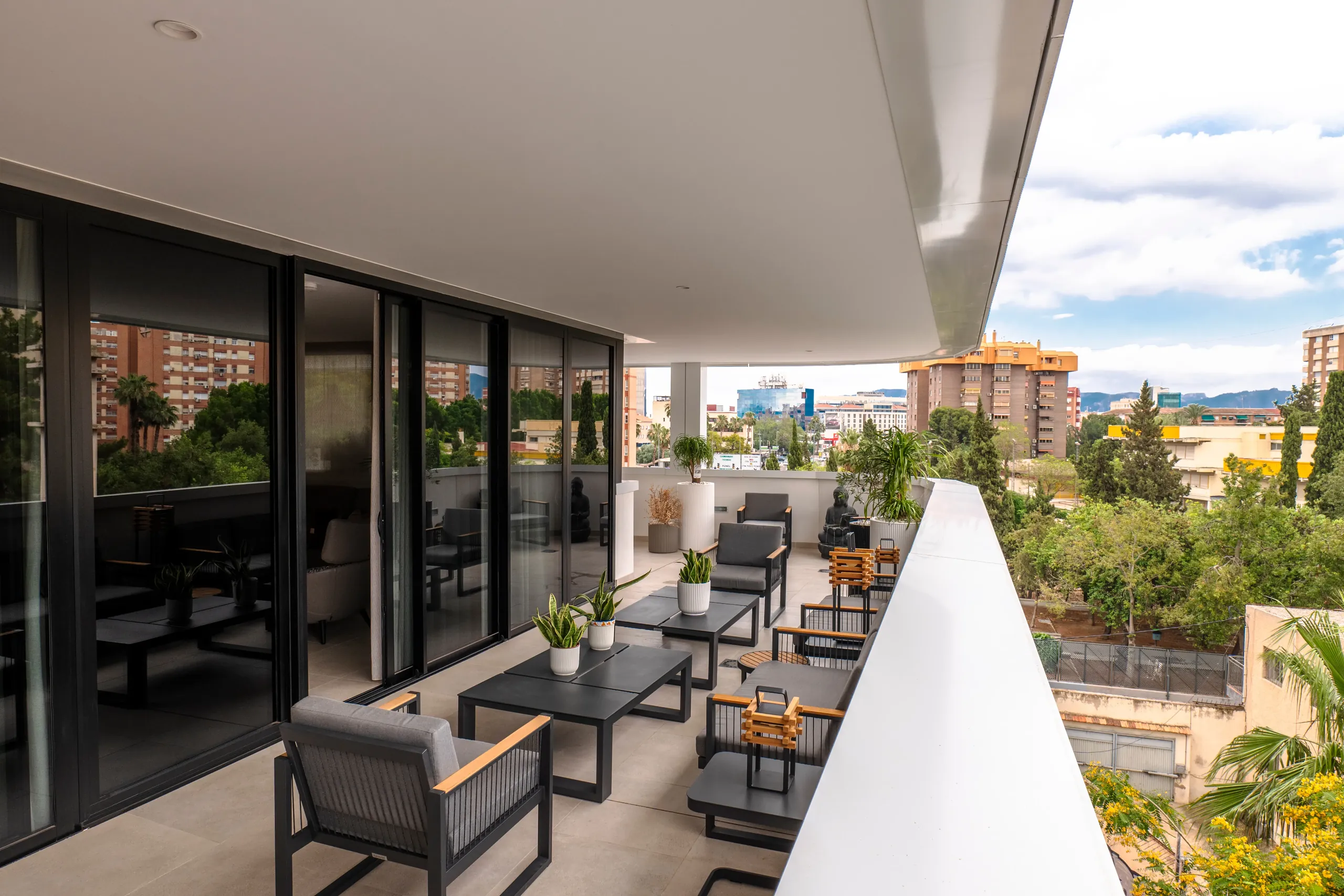 Terraza de un ático con zona de estar y vistas a la ciudad