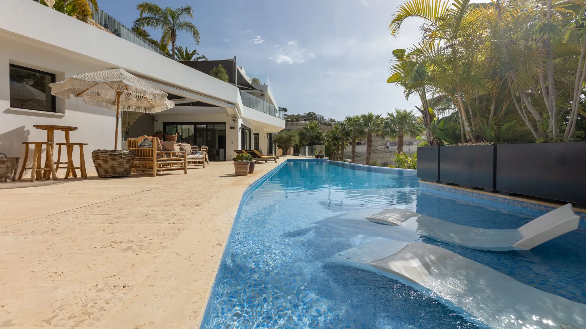 Piscina y terraza con palmeras de una villa de lujo en Alicante, fotografiada por Airpro