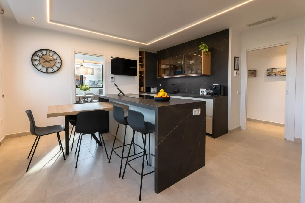 Cocina con isla oscura y vitrinas de madera