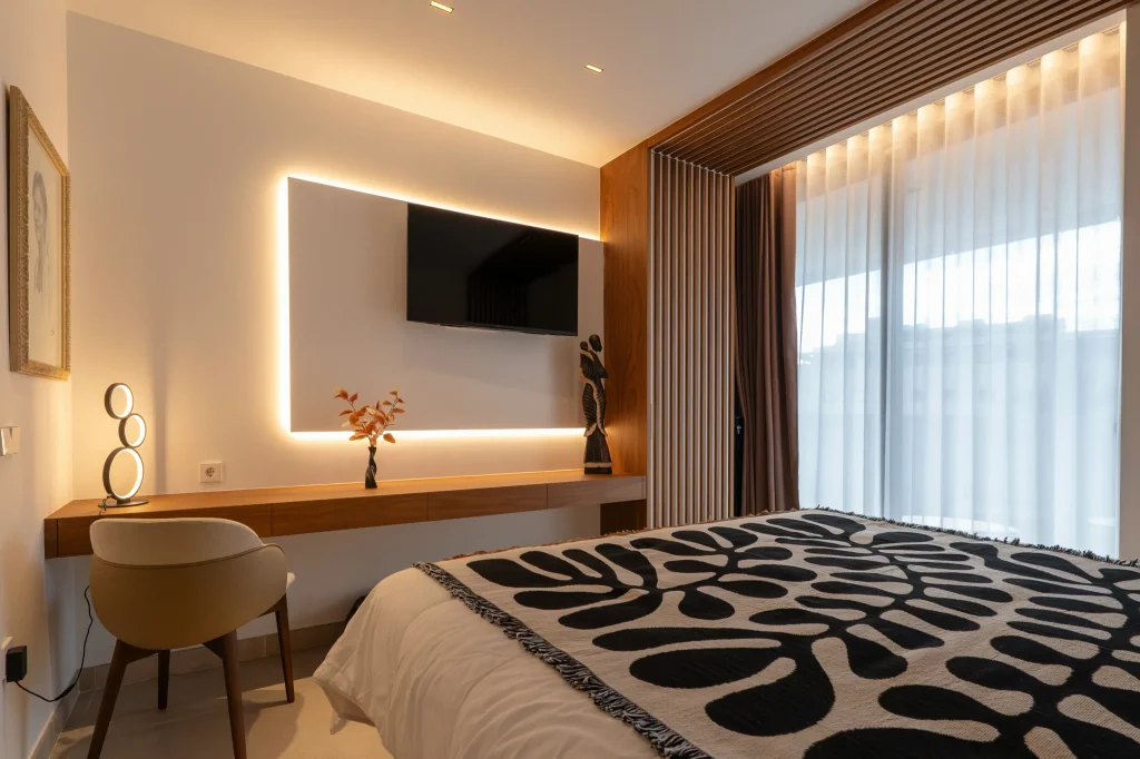 Dormitorio principal con cabecero iluminado y escritorio integrado