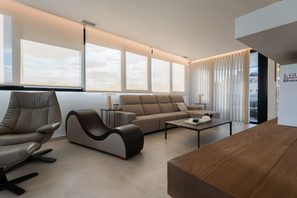 Salón con chaise longue y sofá frente a los ventanales