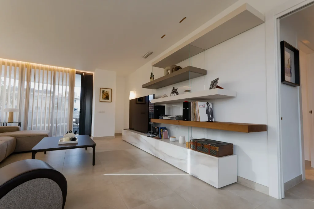Salón con mueble de televisión y estantes de madera flotantes