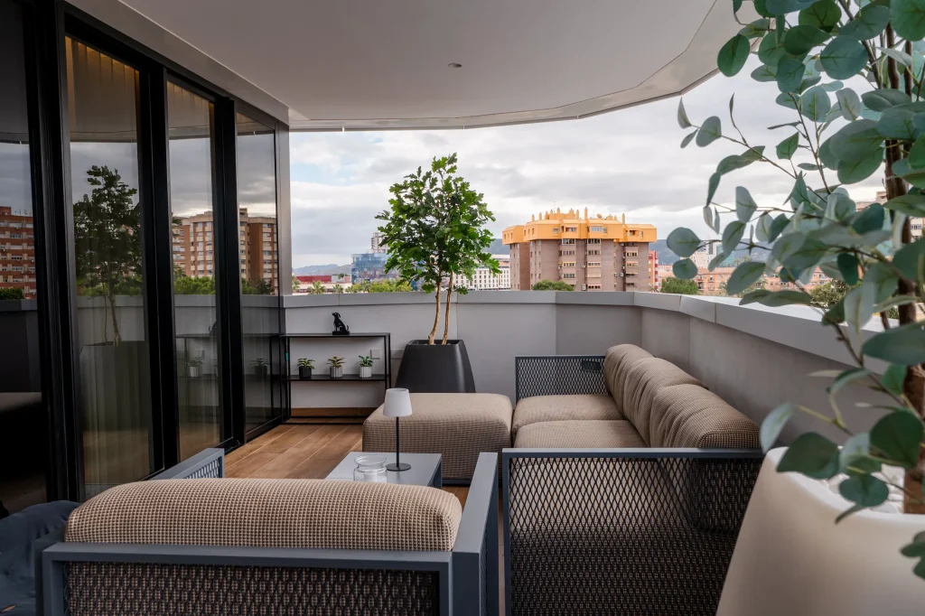 Terraza del ático con sofás exteriores y árboles en maceta