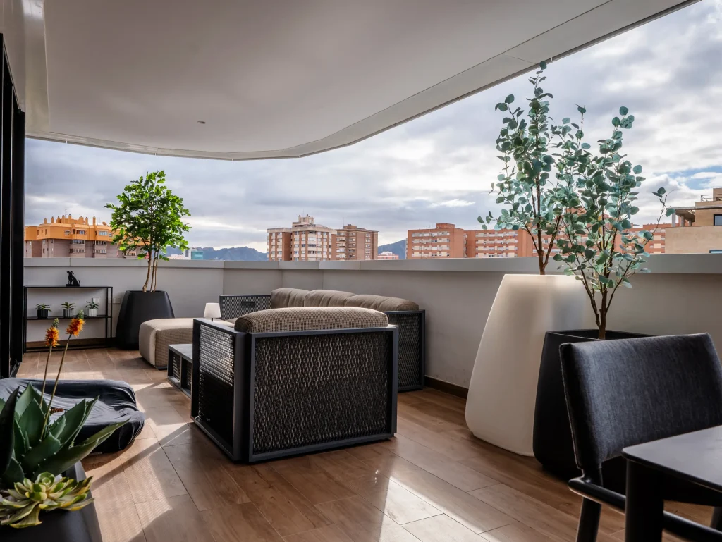 Zona de estar de la terraza con sofás y maceteros grandes
