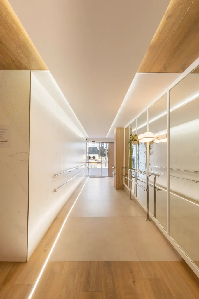 Pasillo del hall con techo de madera y líneas de luz LED