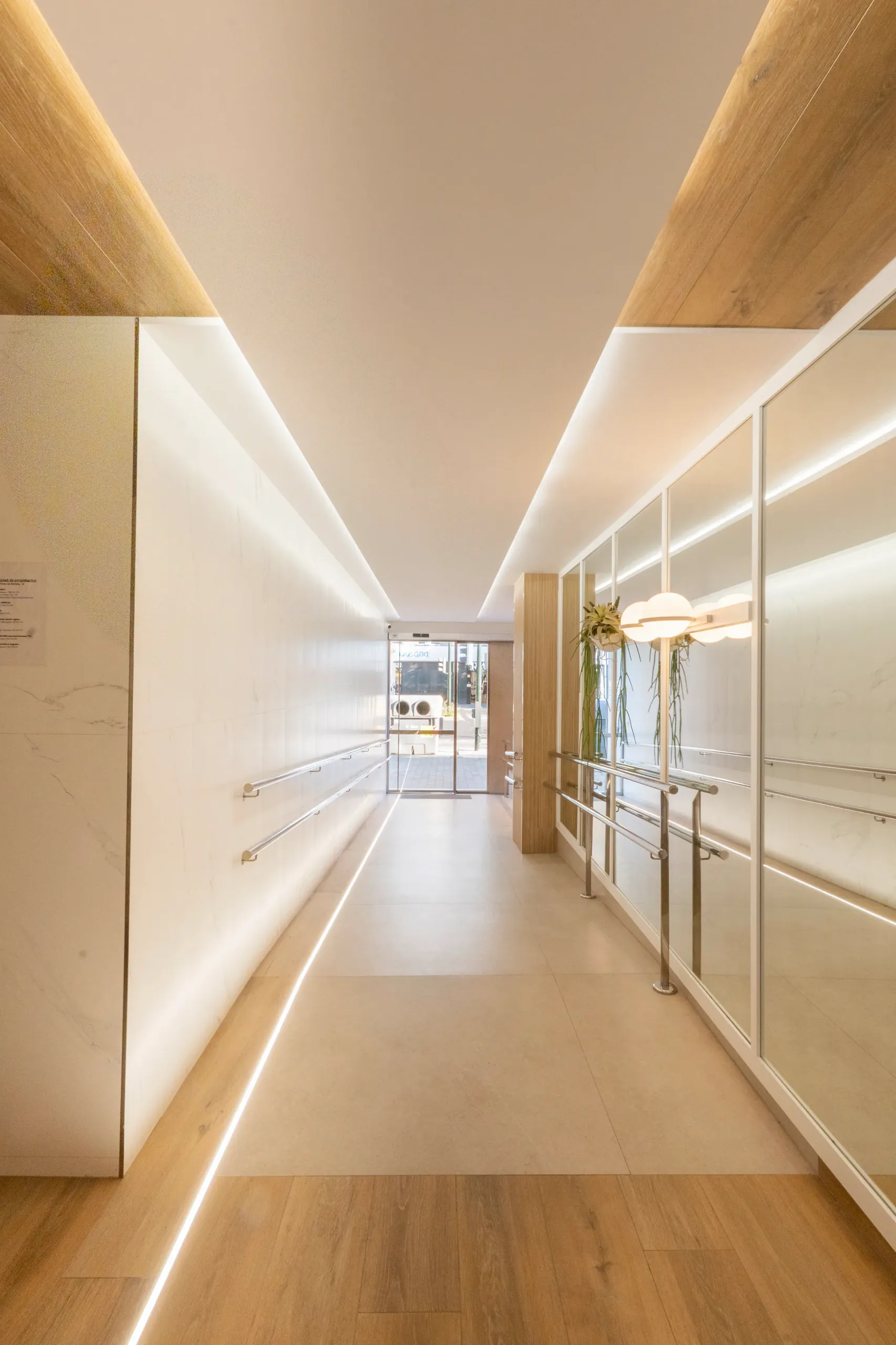 Pasillo del hall con techo de madera y líneas de luz LED
